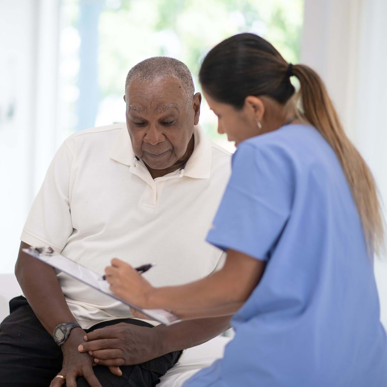 Medical staff speaking to elderly patient