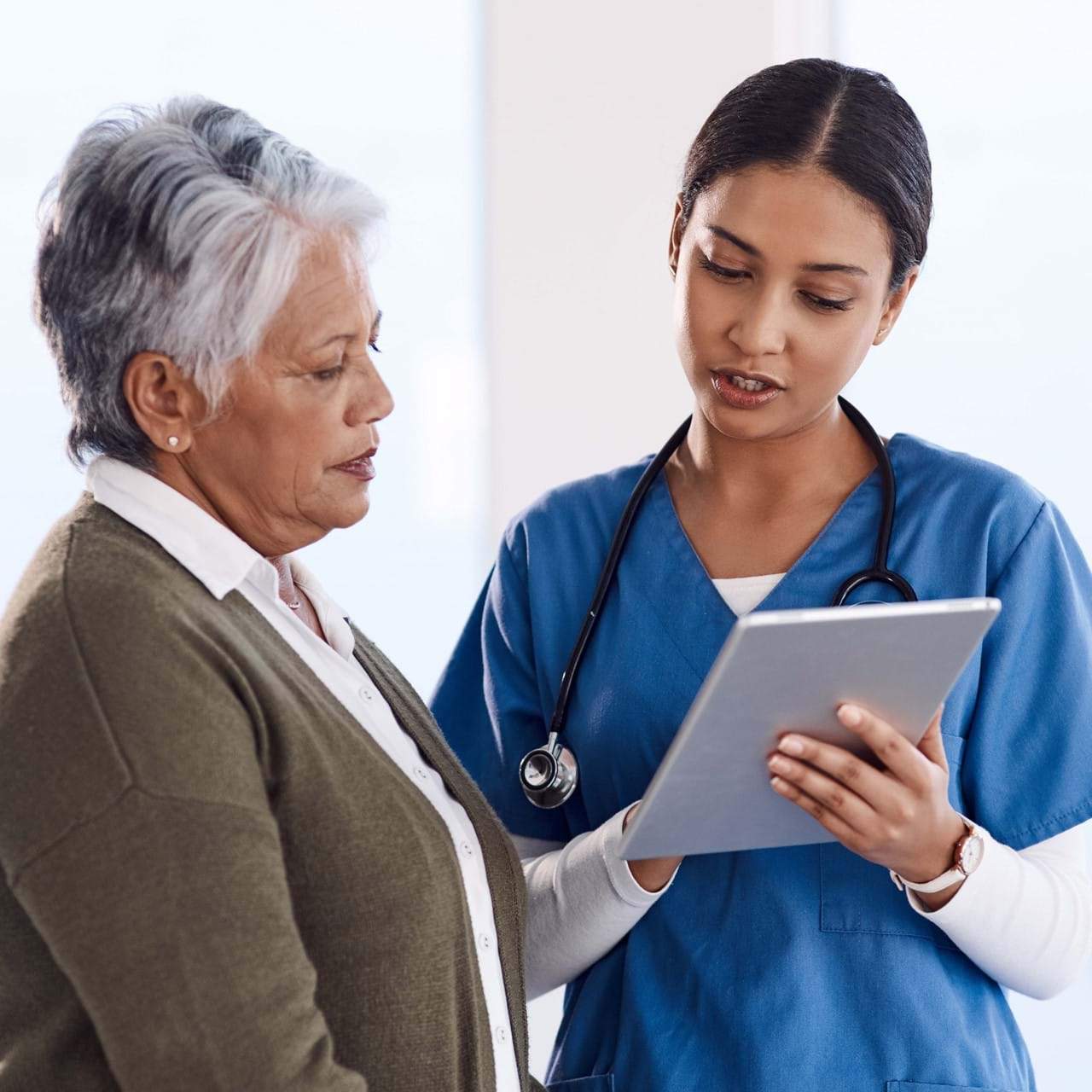 Medical staff speaking to elderly patient