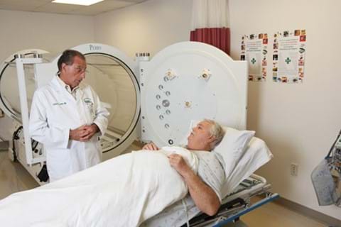 Doctor assisting patient with hyperbaric treatment