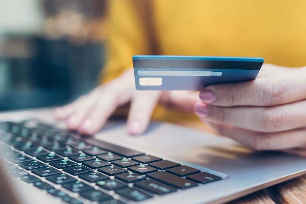 Woman using credit card to make a payment on her laptop